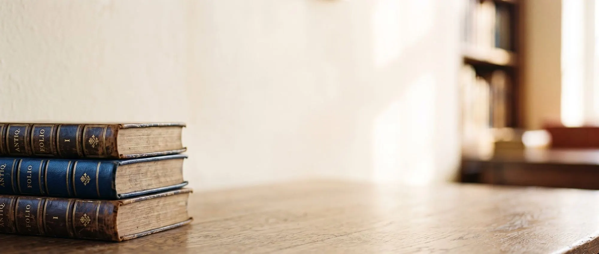 Stacked antique leather-bound books, warm library light
